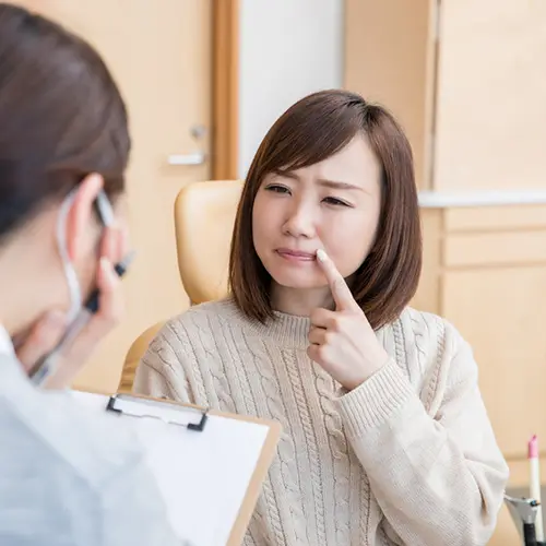 前歯の見た目の悩みを相談する女性