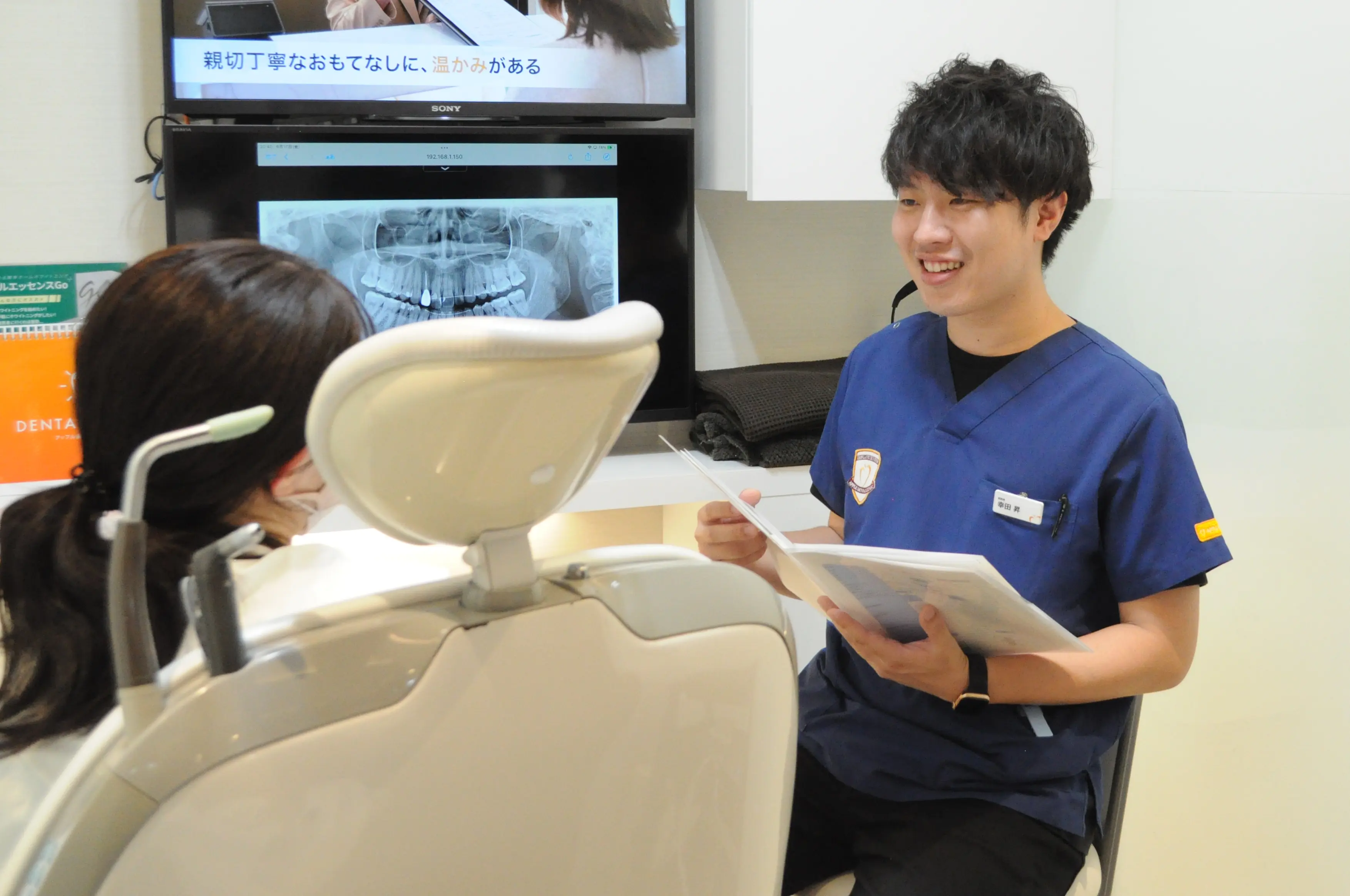 レントゲンを見ながら患者の相談に応じる幸田歯科医師